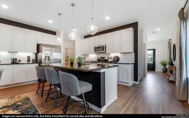 a kitchen with stainless steel appliances granite countertop a stove top oven a sink dishwasher a dining table and chairs with wooden floor