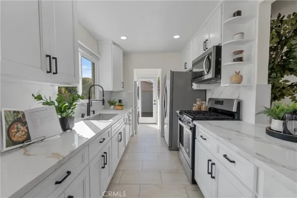 a large kitchen with stainless steel appliances granite countertop a lot of counter space and wooden floor