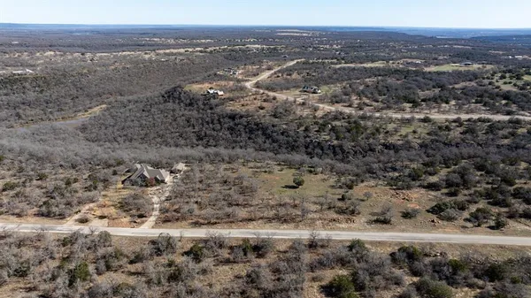 a view of a dry yard with trees