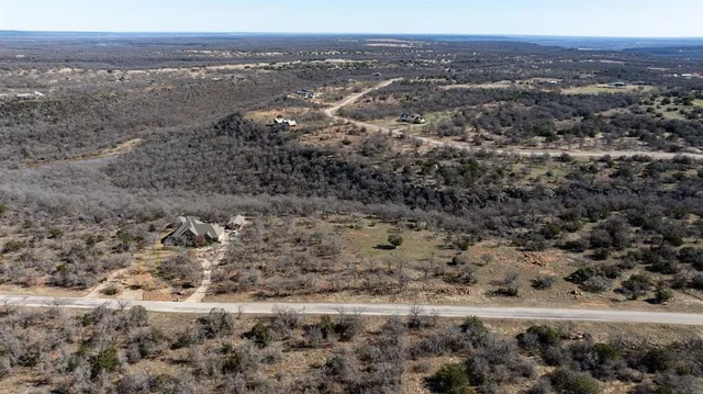 a view of a dry yard with trees