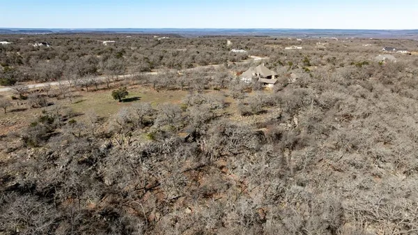 an aerial view of house with yard and mountain view in back
