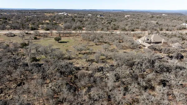 an aerial view of house with yard and mountain in the background