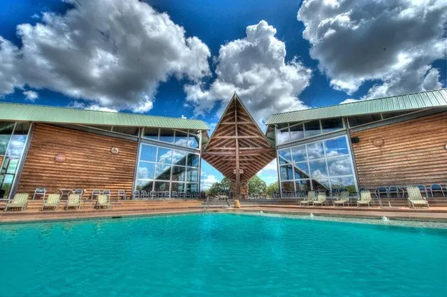 a swimming pool with outdoor seating and barbeque oven