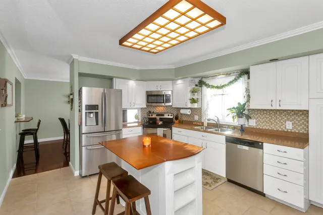 a kitchen with white cabinets and stainless steel appliances