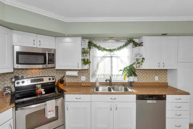 a kitchen with white cabinets and appliances