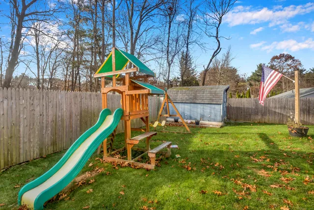 a backyard of a house with lots of green space and wooden fence