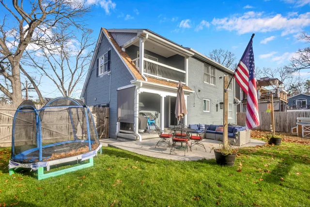 a view of a house with a backyard and a tree