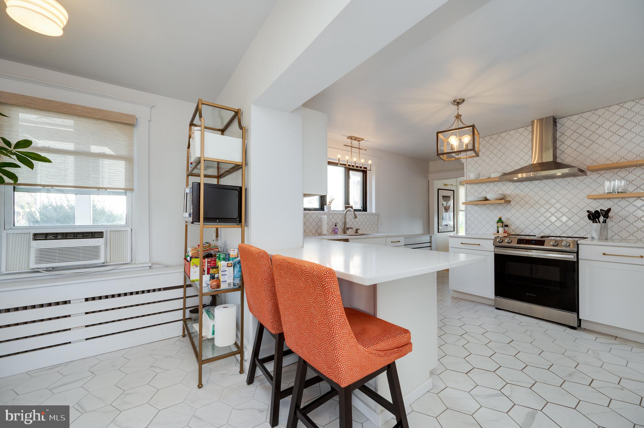 2021 Noble Street Reading, PA 19609 - Photo 23 of 54 a kitchen with stainless steel appliances a stove a sink dishwasher and a refrigerator with wooden floor
