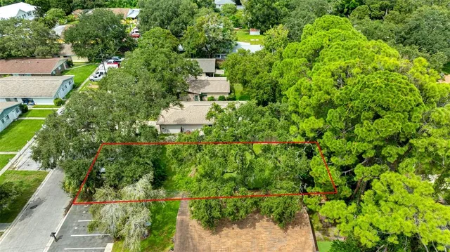 an aerial view of residential house with outdoor space and trees all around