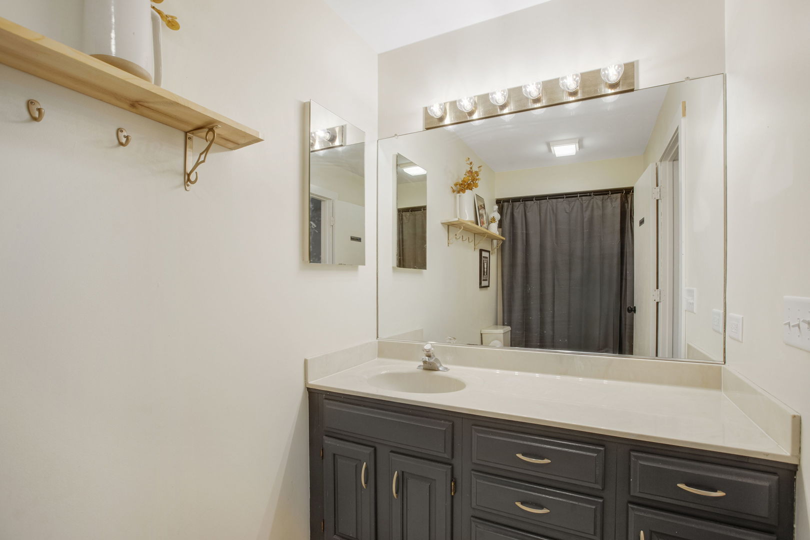 814 Roger Road Woodstock, IL 60098 - Photo 13 of 26 a bathroom with a sink vanity and a mirror