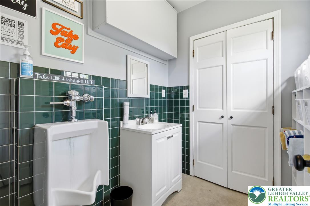 890 Lahr Road Nazareth, PA 18064 - Photo 39 of 71 Functional bath space with a pedestal sink, urinal, and ample storage.