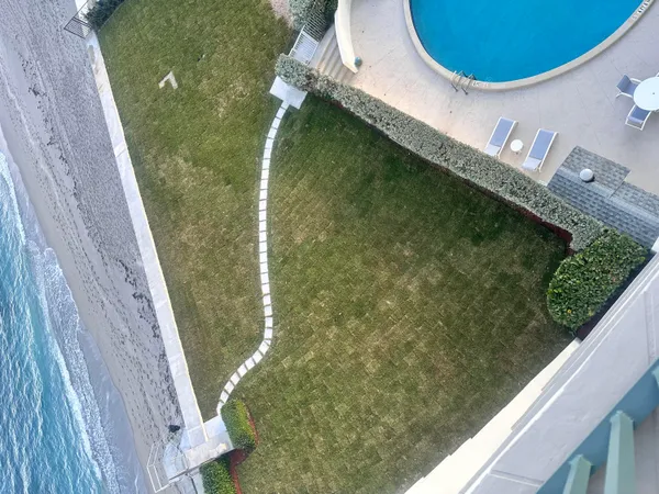 a living room with furniture floor to ceiling window and a rug