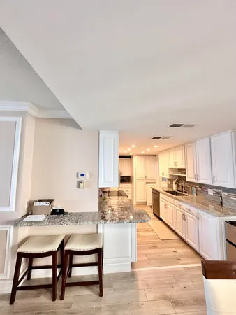 a kitchen with granite countertop a refrigerator and a stove top oven
