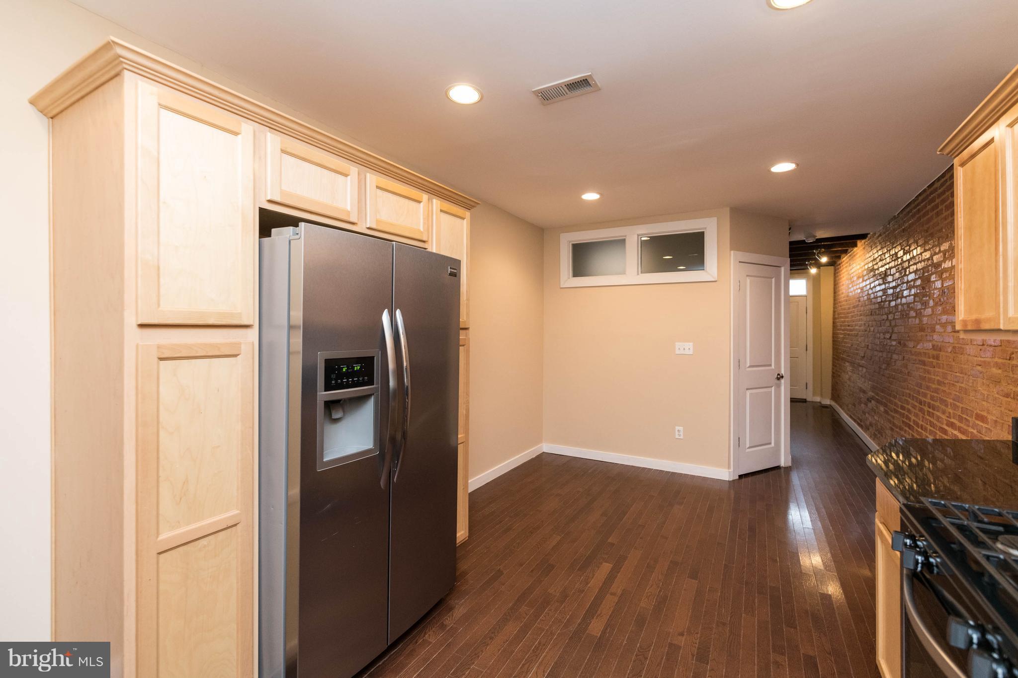 314 West 28th Street Baltimore, MD 21211 - Photo 8 of 27 a view of a refrigerator in kitchen and wooden floor