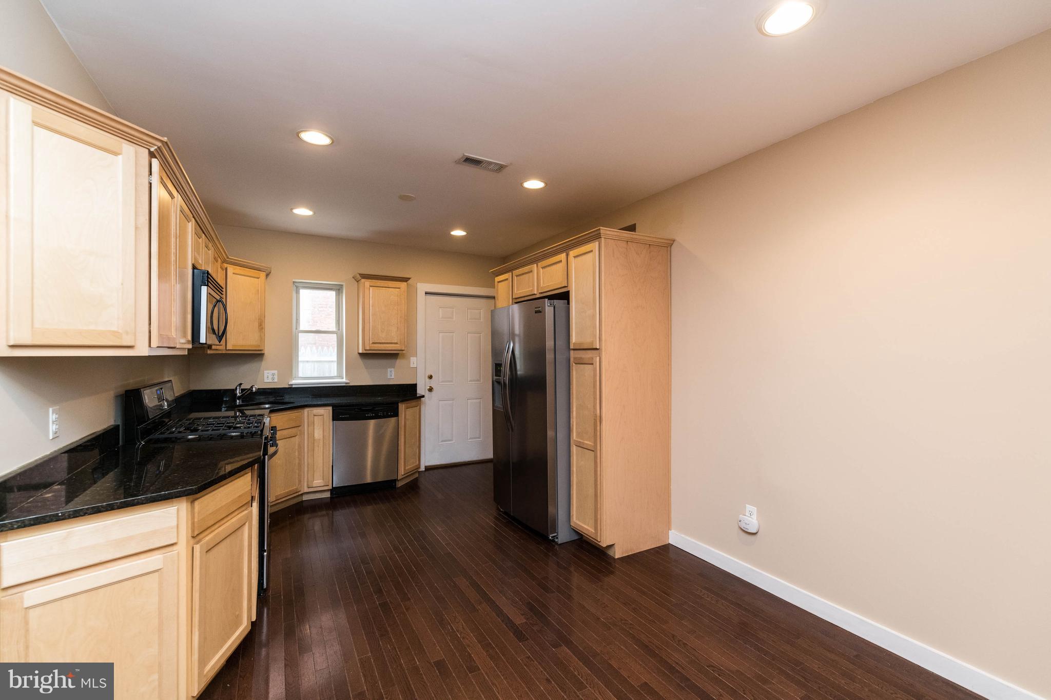 314 West 28th Street Baltimore, MD 21211 - Photo 9 of 27 a kitchen with stainless steel appliances a refrigerator and wooden floor