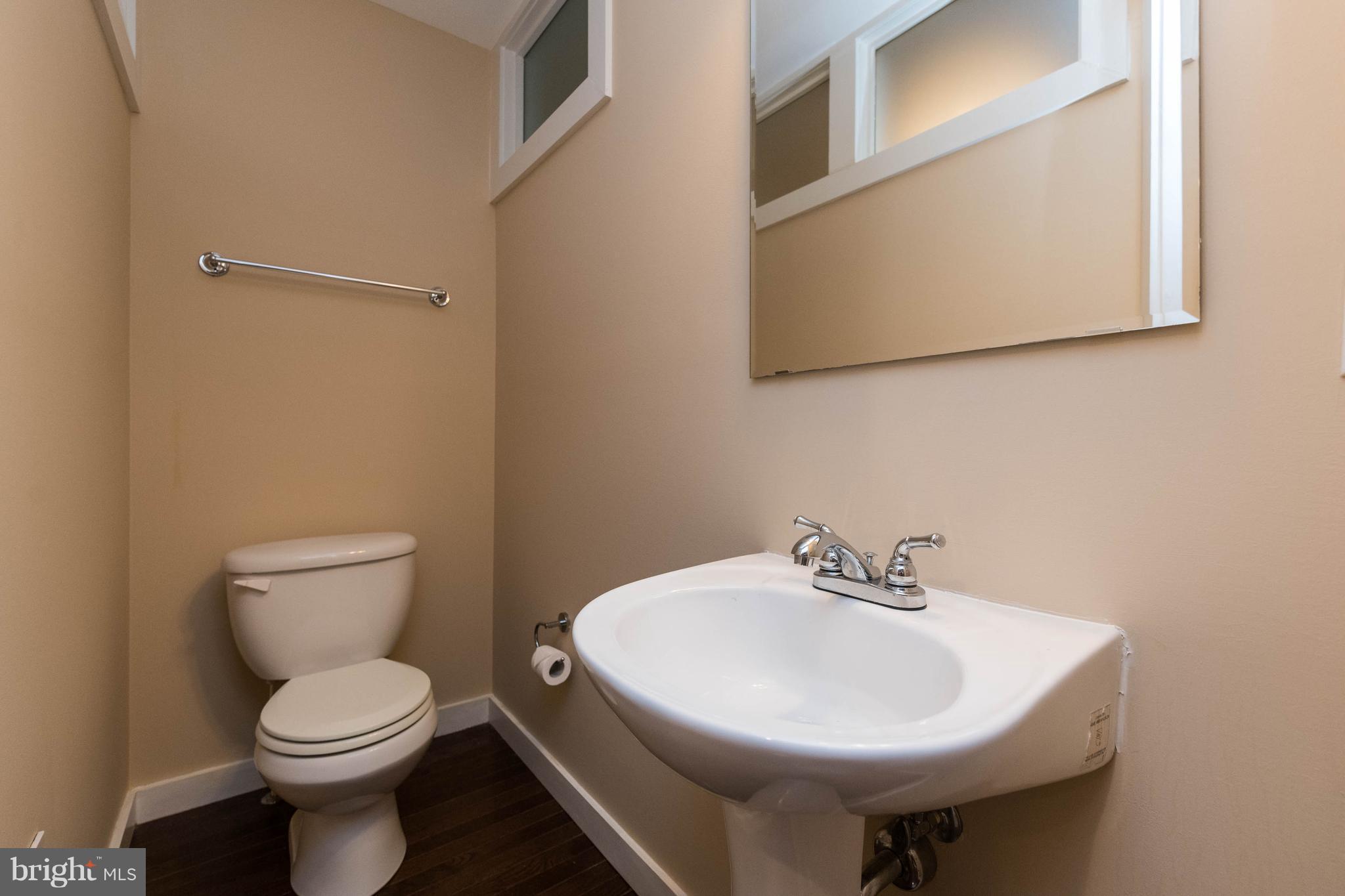 314 West 28th Street Baltimore, MD 21211 - Photo 10 of 27 a bathroom with a sink a toilet and mirror