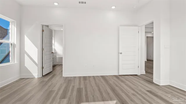an empty room with wooden floor and entrance