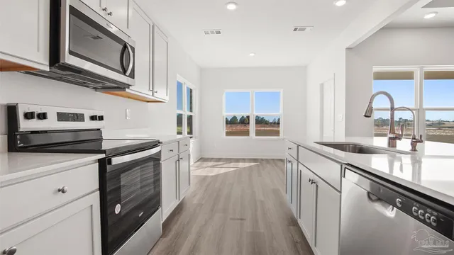 a kitchen with stainless steel appliances granite countertop a stove and a sink