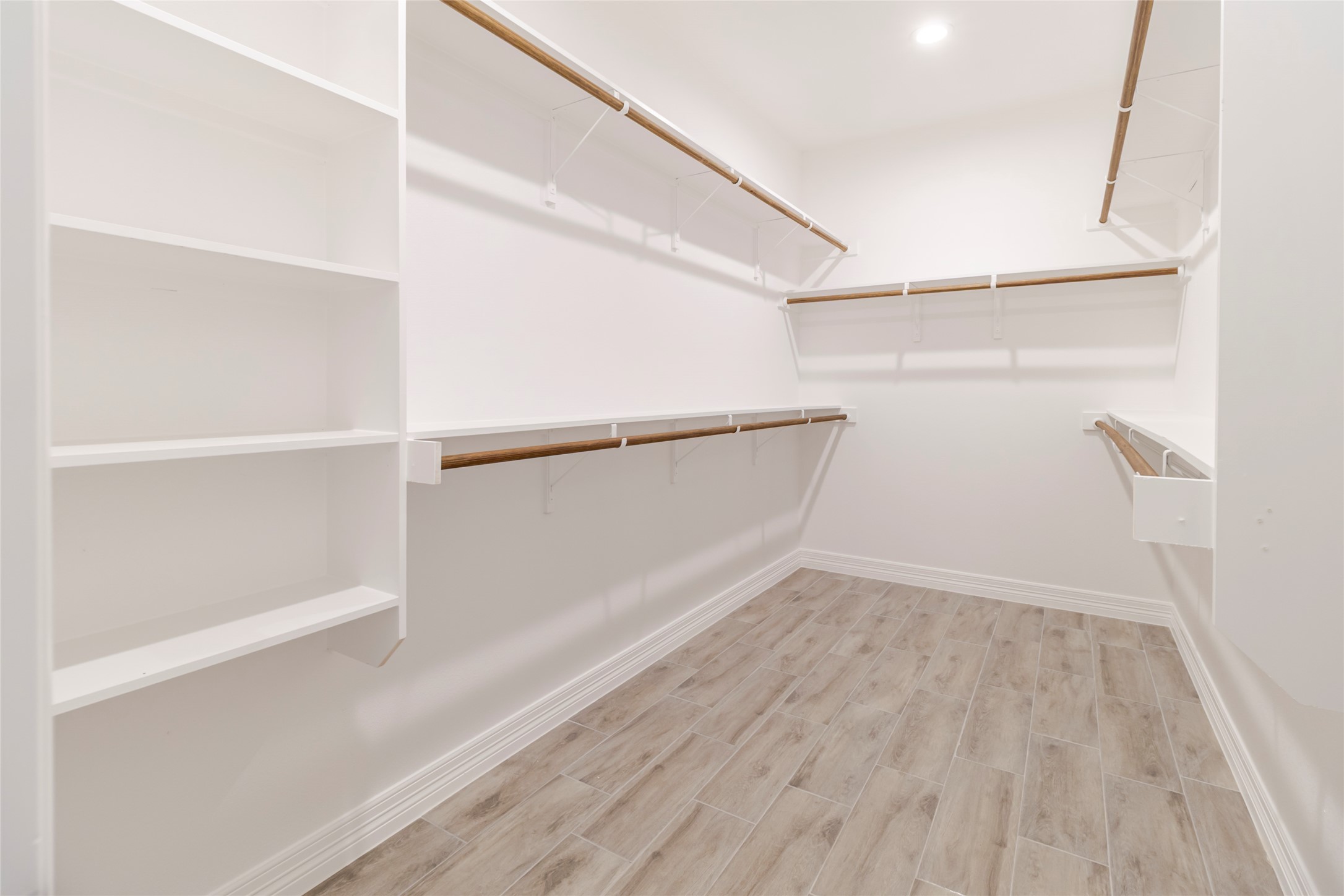 311 Myrtle Road Smithville, TX 78957 - Photo 11 of 16 Shelving and hanging space stretch around the walk-in closet instead of stopping at a single rod.