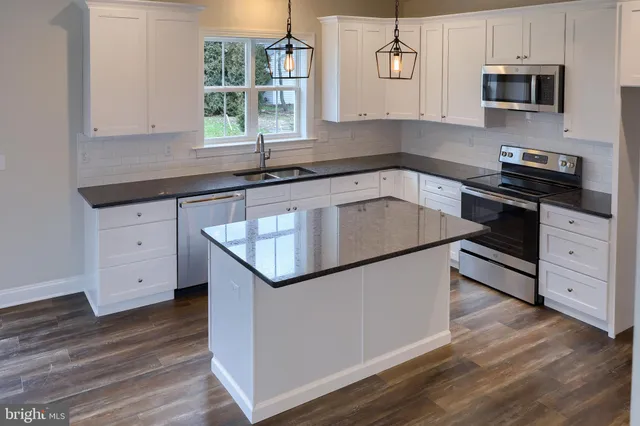 a kitchen with stainless steel appliances granite countertop a sink stove and microwave