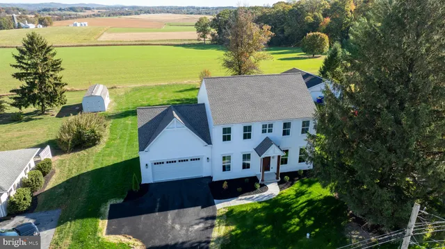 an aerial view of a house with a garden and lake view
