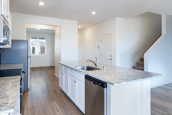 a kitchen with a sink a counter space and wooden floor