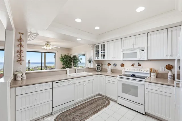 a kitchen with a sink dishwasher window and cabinets
