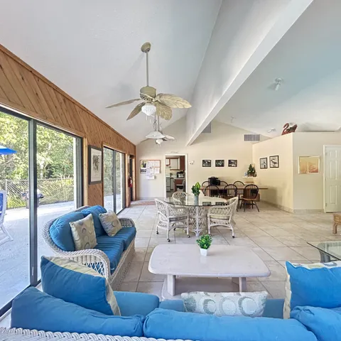 a dining room with furniture and a floor to ceiling window