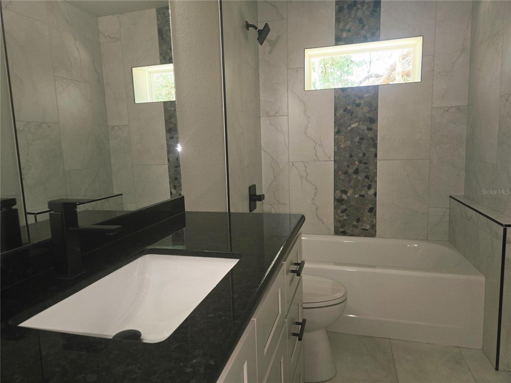 8541 Northeast 105th Avenue Bronson, FL 32621 - Photo 11 of 20 a bathroom with a sink a toilet and shower