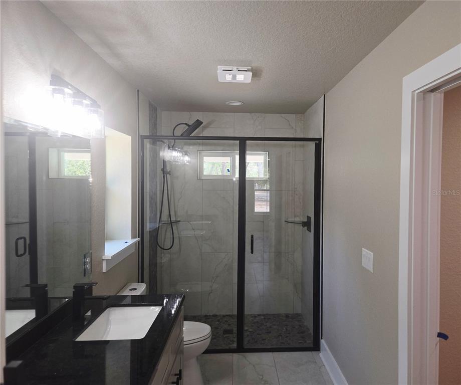8541 Northeast 105th Avenue Bronson, FL 32621 - Photo 16 of 20 a bathroom with a double vanity sink toilet and shower