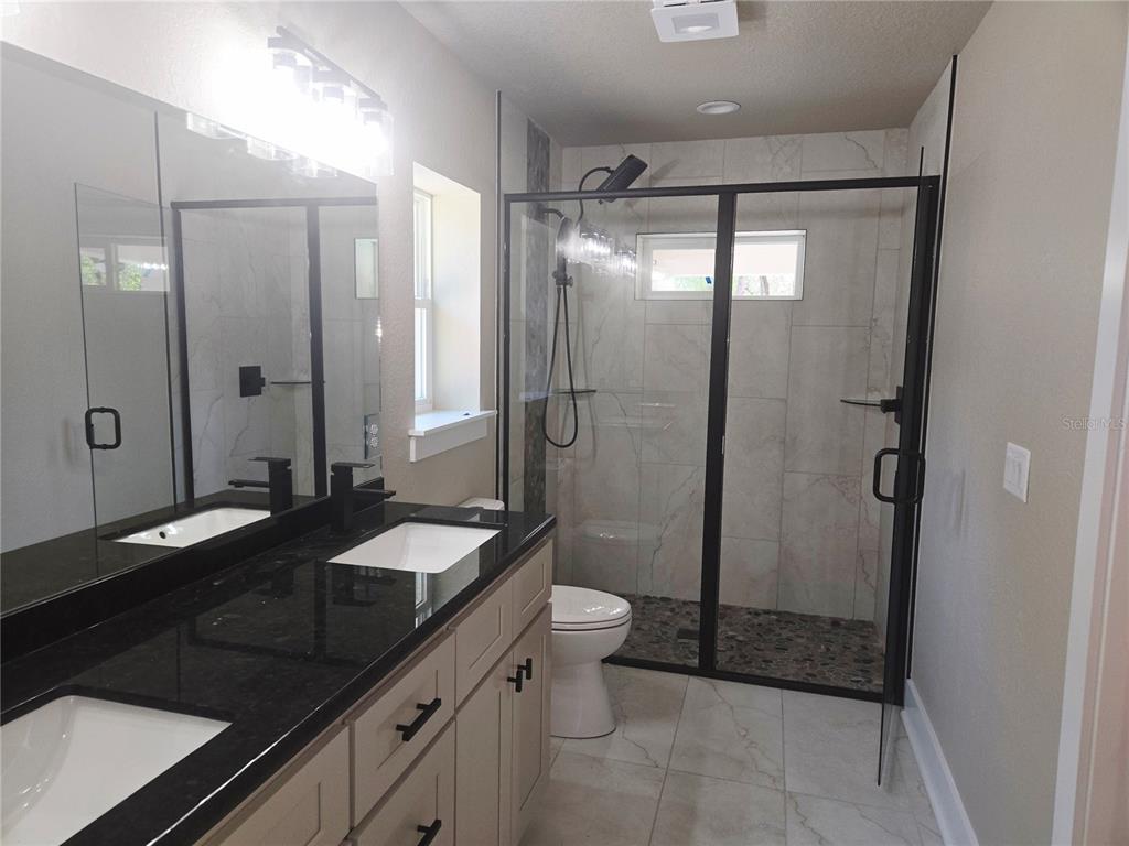 8541 Northeast 105th Avenue Bronson, FL 32621 - Photo 17 of 20 a bathroom with a granite countertop sink toilet and shower