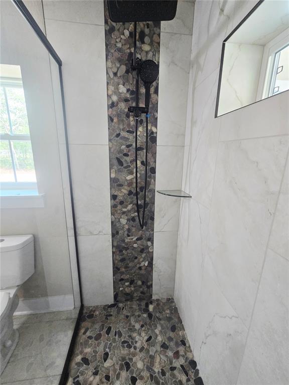8541 Northeast 105th Avenue Bronson, FL 32621 - Photo 19 of 20 a bathroom with a granite countertop shower and a toilet