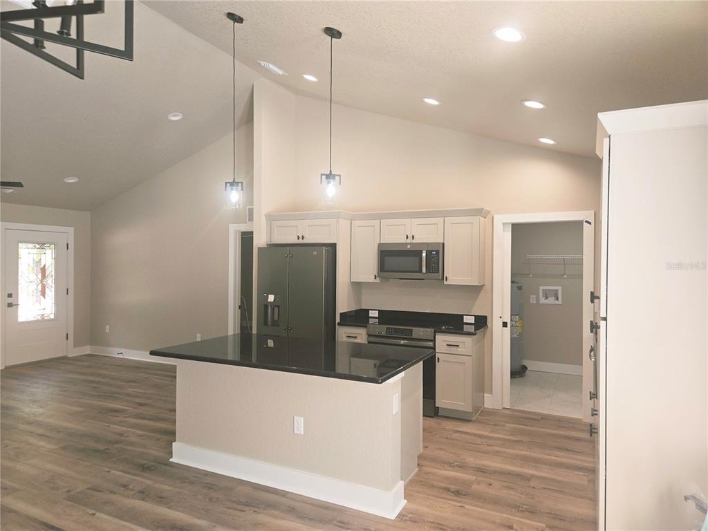 8541 Northeast 105th Avenue Bronson, FL 32621 - Photo 8 of 20 a kitchen with stainless steel appliances granite countertop a refrigerator a sink and a stove