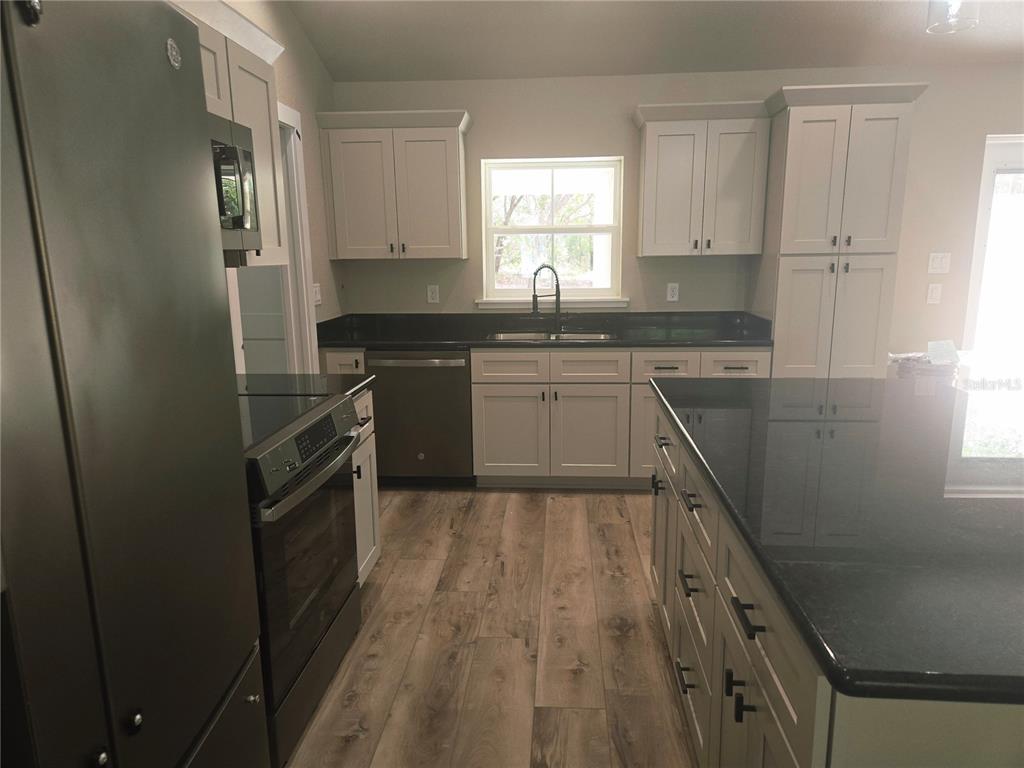 8541 Northeast 105th Avenue Bronson, FL 32621 - Photo 10 of 20 a kitchen with granite countertop a sink stove and refrigerator