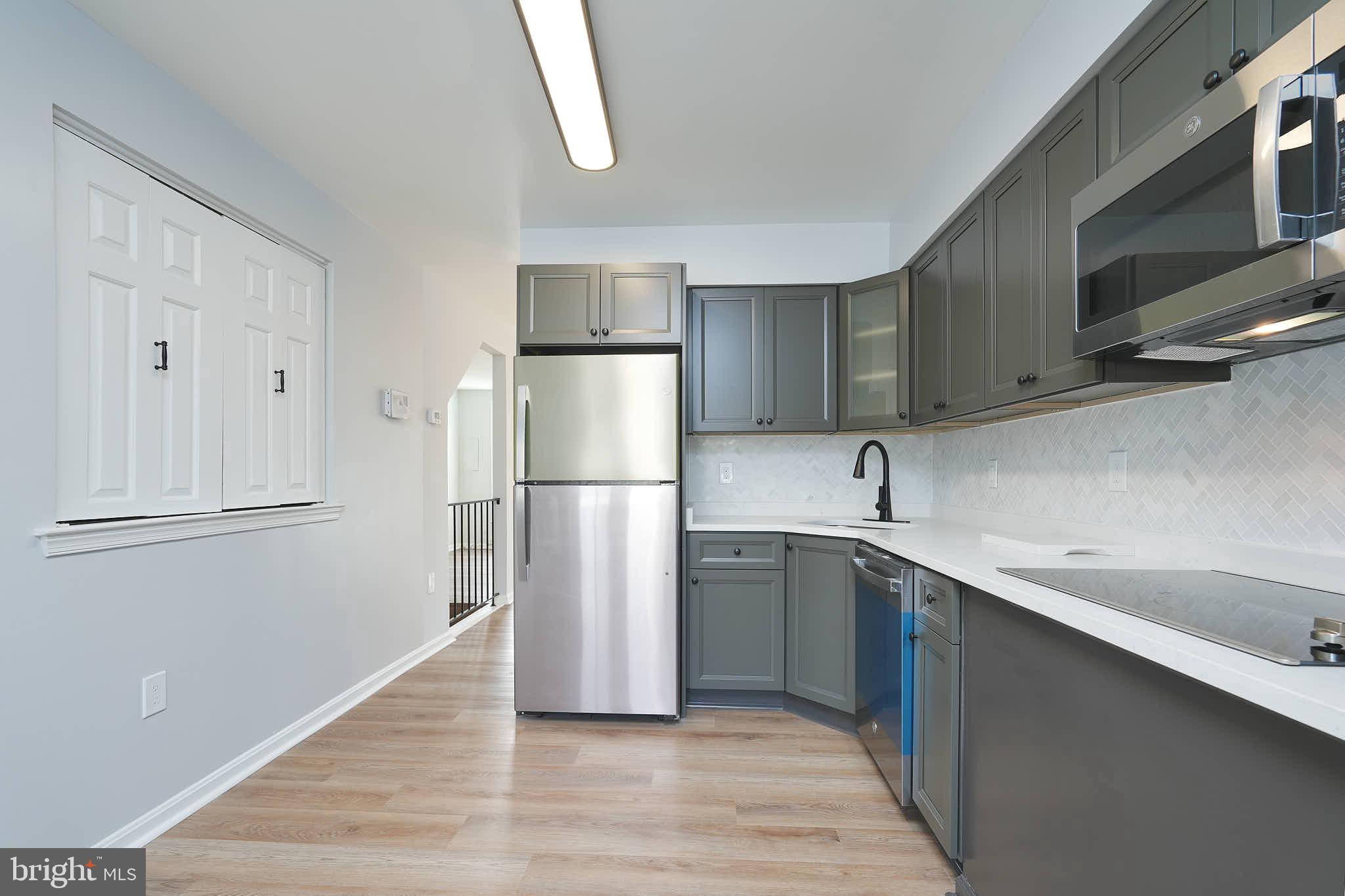 7938 Brighton Way Manassas, VA 20109 - Photo 12 of 26 a kitchen with a refrigerator sink and cabinets