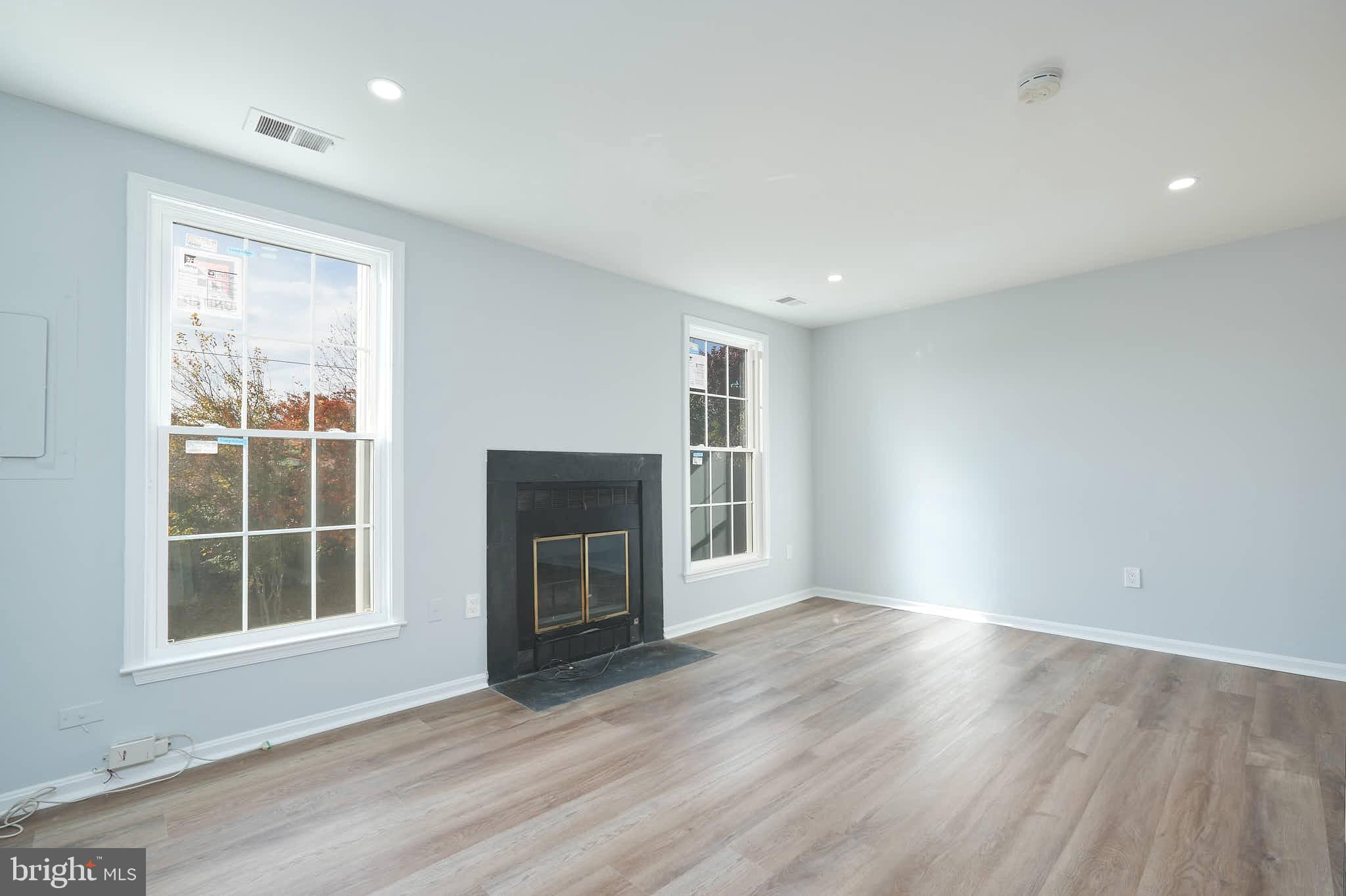 7938 Brighton Way Manassas, VA 20109 - Photo 5 of 26 an empty room with wooden floor fireplace and windows