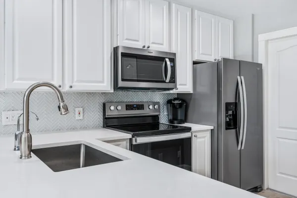 a kitchen with granite countertop a refrigerator and a sink