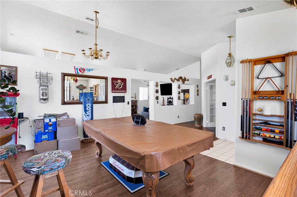 13863 Coachella Road Apple Valley, CA 92307 - Photo 12 of 53 a living room with dining table and paintings on the wall