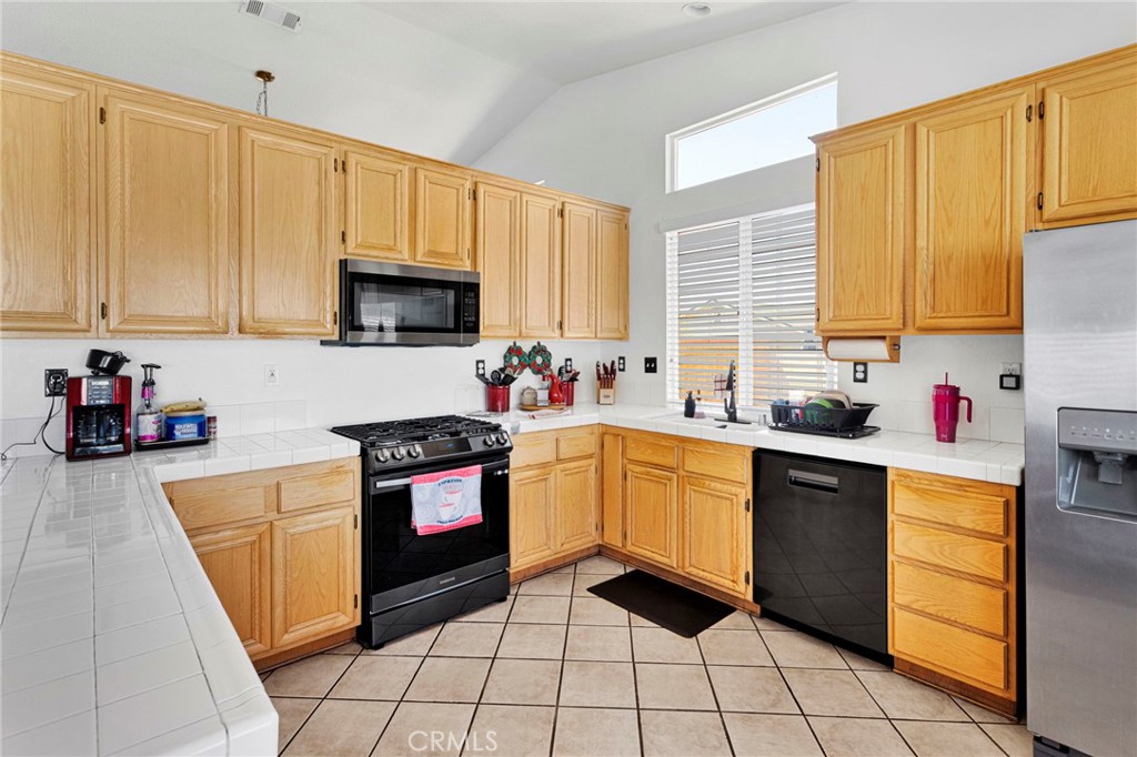 13863 Coachella Road Apple Valley, CA 92307 - Photo 20 of 53 a kitchen with granite countertop a stove sink and cabinets