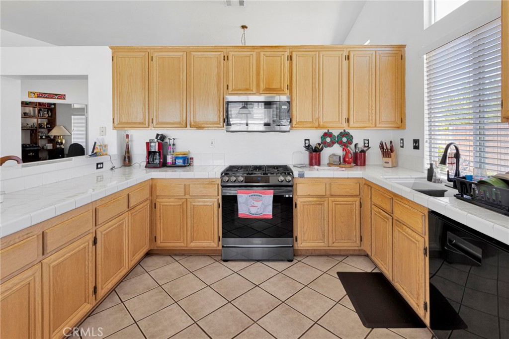 13863 Coachella Road Apple Valley, CA 92307 - Photo 21 of 53 a kitchen with a sink cabinets and window