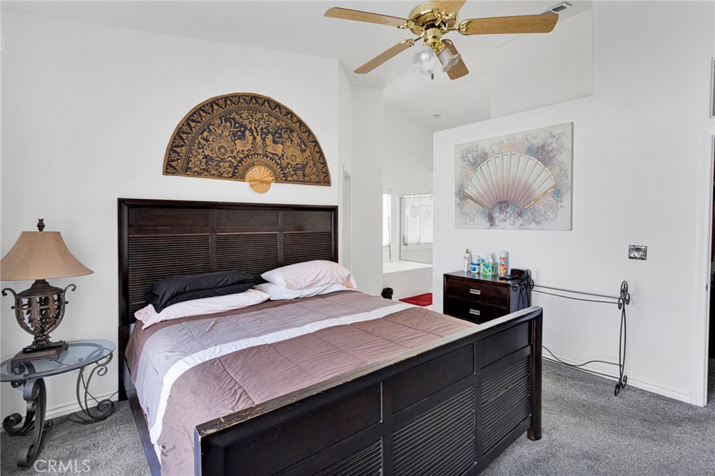 13863 Coachella Road Apple Valley, CA 92307 - Photo 25 of 53 a bedroom with a bed and a chandelier
