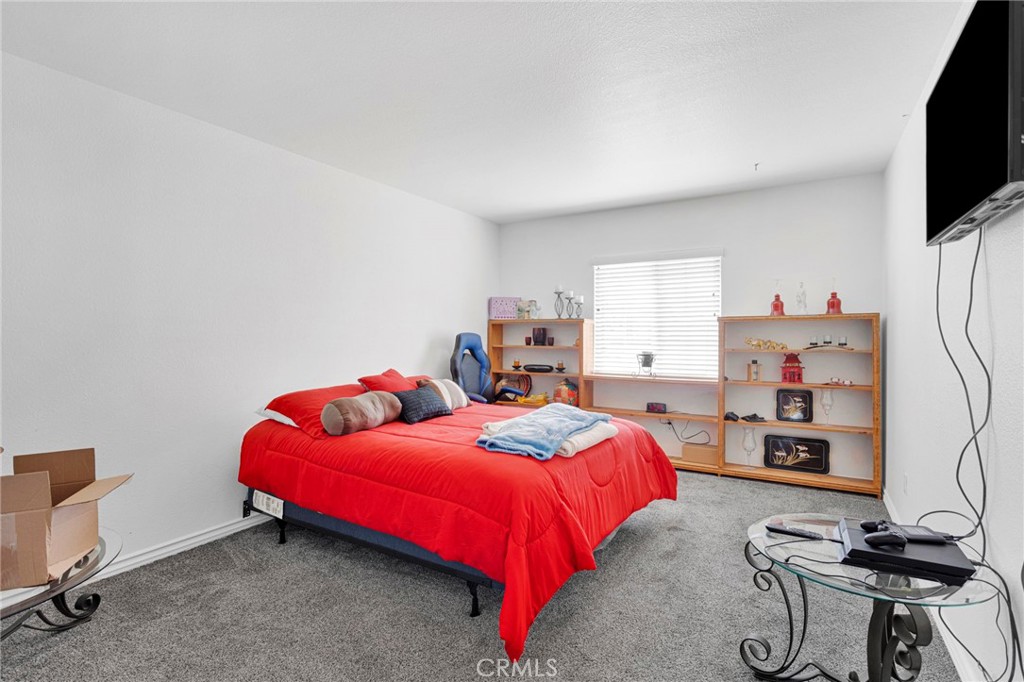 13863 Coachella Road Apple Valley, CA 92307 - Photo 35 of 53 a bedroom with a bed and a flat screen tv