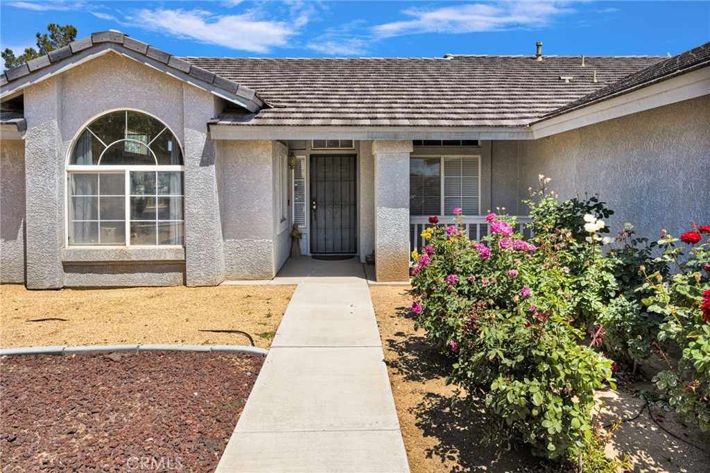 13863 Coachella Road Apple Valley, CA 92307 - Photo 4 of 53 a front view of a house with a garden