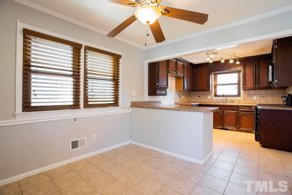 4200 Pike Road Raleigh, NC 27613 - Photo 14 of 30 a kitchen with granite countertop a stove a sink and a microwave