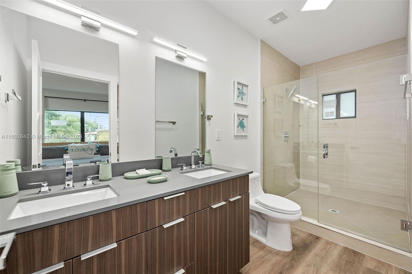 Allapattah Miami, FL 33142 - Photo 17 of 27 a bathroom with a double vanity sink toilet mirror and shower