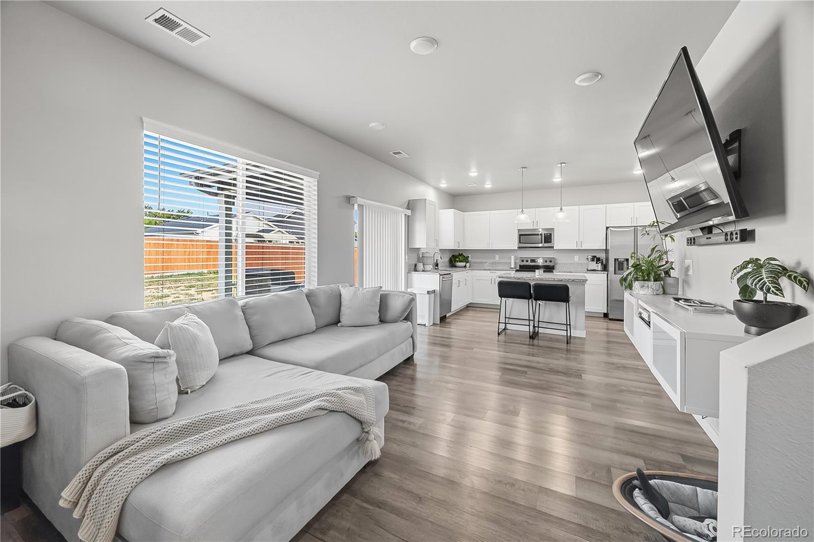 669 South Hoover Avenue Fort Lupton, CO 80621 - Photo 11 of 24 a living room with furniture wooden floor and a flat screen tv