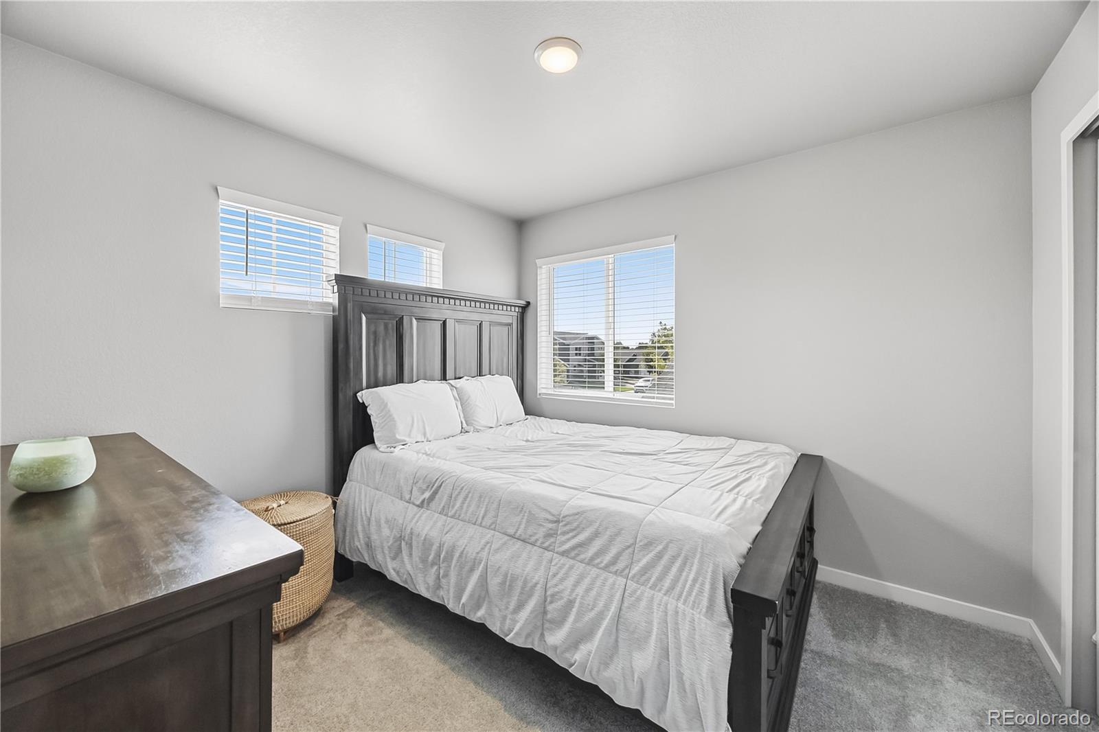 669 South Hoover Avenue Fort Lupton, CO 80621 - Photo 15 of 24 a bedroom with a bed and a window