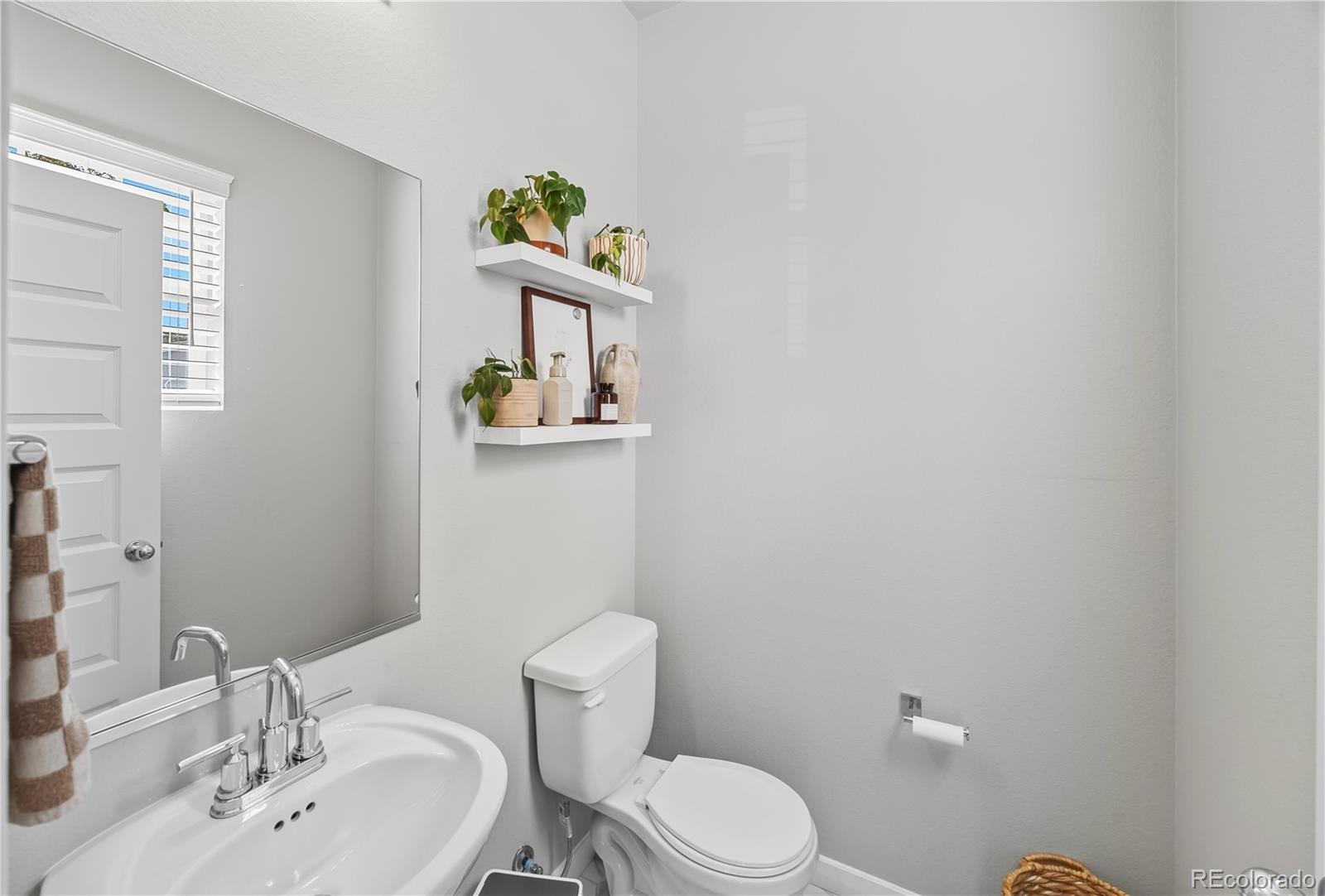 669 South Hoover Avenue Fort Lupton, CO 80621 - Photo 6 of 24 a bathroom with a toilet sink and mirror