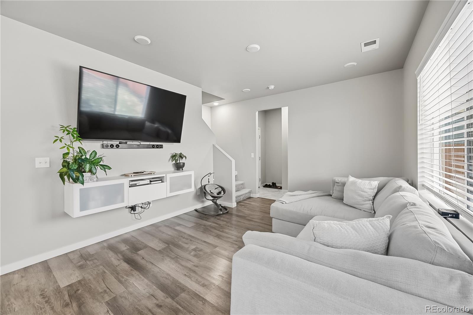 669 South Hoover Avenue Fort Lupton, CO 80621 - Photo 10 of 24 a living room with furniture and a flat screen tv