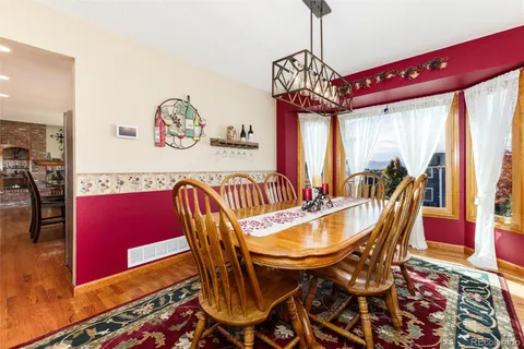 a dining room with furniture a chandelier and wooden floor